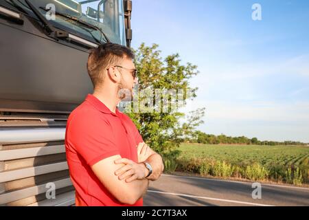 Conducente maschio vicino a camion grande all'aperto Foto Stock