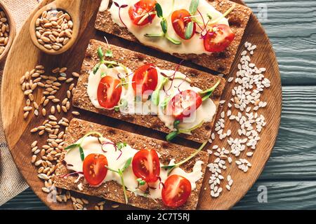 Gustosi croccanti con pomodoro, formaggio e germogli sul piatto Foto Stock