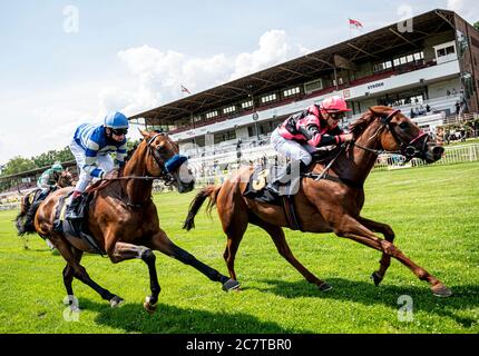 Hoppegarten, Germania. 19 luglio 2020. Sport equestri: Galoppo, gara giorno all'ippodromo Hoppegarten. Jockey Wladimir Panov (r) sul volo di Gina's dalla scuderia di Aesch vince contro Jockey Andrasch Starke sul sombrero della scuderia di Vesterberg alla gara di Georgiew Elektrouplinstallation. Per la prima volta dall'inizio della pandemia del coronavirus, la corsa si svolge con gli spettatori. Credit: Fabian Sommer/dpa/Alamy Live News Foto Stock