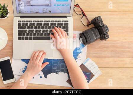 Donna con stanza per la prenotazione di un computer portatile in hotel online al tavolo Foto Stock