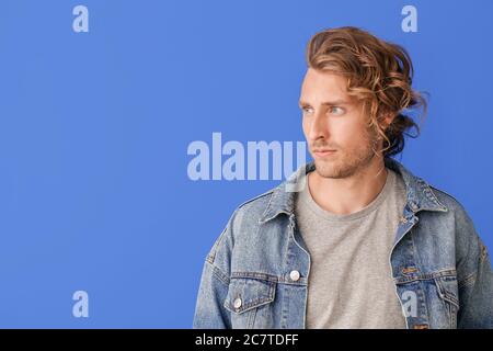 Bell'uomo con capelli eleganti su sfondo colorato Foto Stock