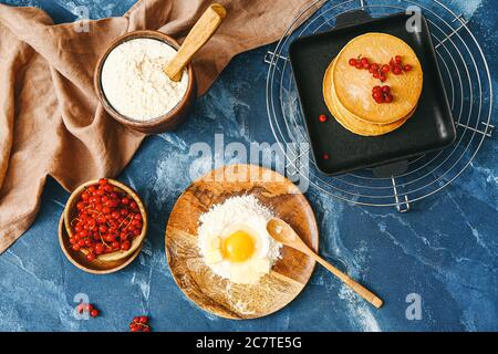 Gustosi pancake con ingredienti su sfondo colorato Foto Stock