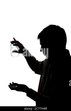 Giovane uomo che beve un bicchiere di acqua frizzante, senza acqua - silhouette Foto Stock