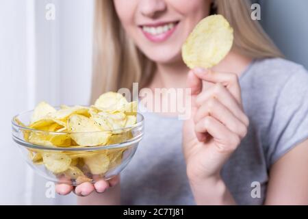 ciotola con patatine in mani femminili Foto Stock