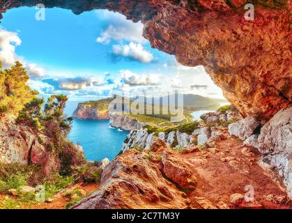 Fantastica vista mattutina sul capo Cacccia. Vista dalla grotta sulla scogliera. Fantastico mare Mediterraneo. Località: Alghero, Provincia di Sassari, i Foto Stock