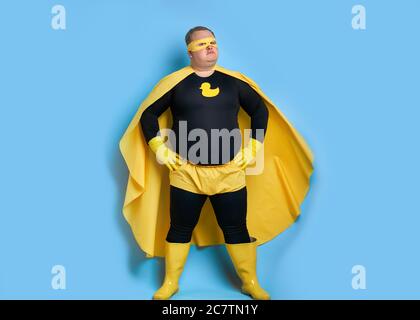 salviamo il pianeta da ritratto di sporco di uomo grasso di pulizia in costume giallo isolato su sfondo blu Foto Stock