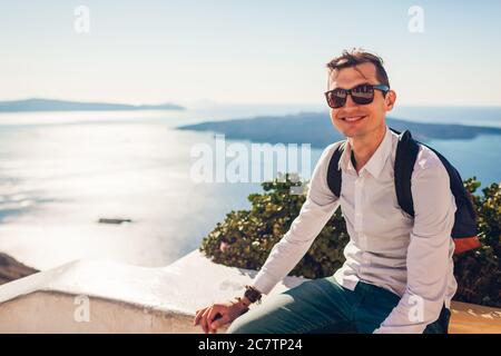 L'uomo che viaggia a Santorini si rilassa godendo la vista del paesaggio della Caldera a Fira, Grecia. Turismo, viaggio, vacanza estiva Foto Stock