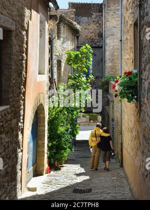 BONNIEUX, FRANCIA - 11 LUGLIO 2014: Turisti sulla strada stretta del bellissimo borgo medievale di Bonnieux. Bonnieux villaggio è incluso nella lista di Foto Stock