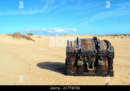 Concettuale immagine fotografica di un tesoro oggetto del trunk nel deserto secco Foto Stock