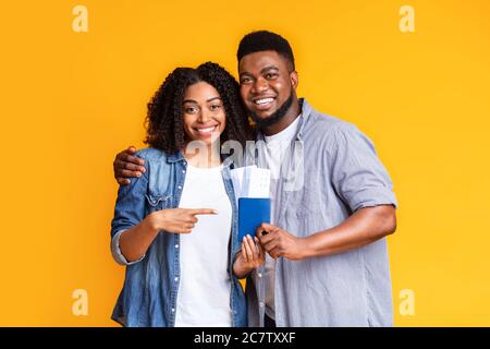 Tempo di viaggio. Happy Black coniugi Ponting ai passaporti con biglietti di volo Foto Stock