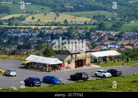 Cow & Calf Rock Cafe (esterno) e parcheggio auto su una splendida brughiera che si affaccia su terreni agricoli e case in valle - Ilkley Moor, West Yorkshire, Inghilterra, Regno Unito. Foto Stock