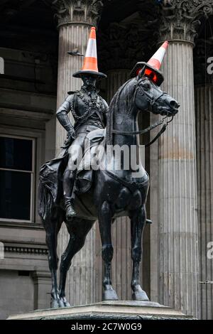 Famosa statua del Duca di Wellington con coni stradali in testa in Royal Exchange Square, Glasgow, Scozia, Regno Unito Foto Stock