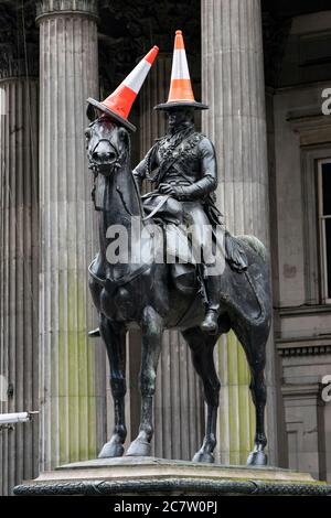 Famosa statua del Duca di Wellington con coni stradali in testa in Royal Exchange Square, Glasgow, Scozia, Regno Unito Foto Stock