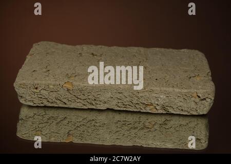 dolce halva isolato su sfondo rosso su tovagliolo di burlap Foto Stock