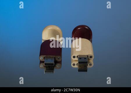 Due chiavette usb con cappuccio aperto in legno, fondo blu Foto Stock