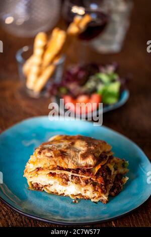 Lasagna di fresco su una piastra di colore blu Foto Stock