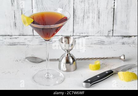 Bicchiere di cocktail Martinez guarnito con scorza di limone Foto Stock