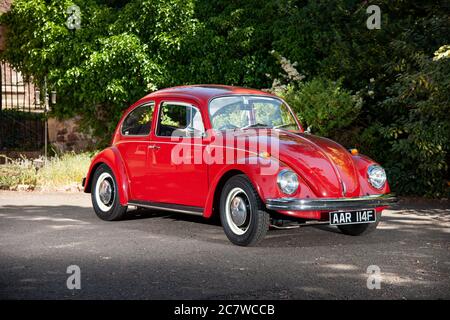 Volkswagen Beetle parcheggiato sul cortile di una casa in un pomeriggio estivo soleggiato Foto Stock