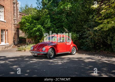 Volkswagen Beetle parcheggiato sul cortile di una casa in un pomeriggio estivo soleggiato Foto Stock