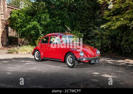 Volkswagen Beetle parcheggiato sul cortile di una casa in un pomeriggio estivo soleggiato Foto Stock