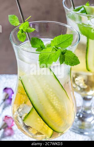 Coda di mocktail con succo di mela e di sambuco con cetrioli, menta e cubetti di ghiaccio - rinfrescante bevanda analcolica estiva Foto Stock