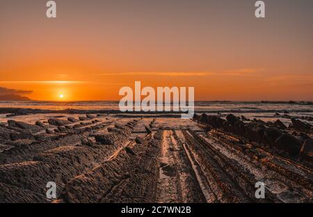 Vista del bellissimo tramonto arancione sul fiocco di La spiaggia di Sakoneta Foto Stock