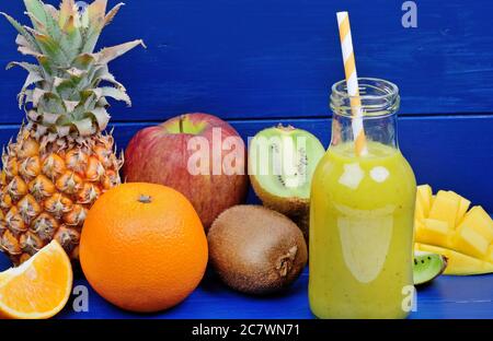 Delizioso frullato detox in un bicchiere su un tavolo di legno blu Foto Stock