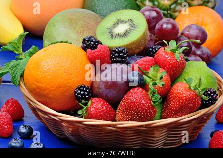 Mescolare la frutta colorata in un cestino su un tavolo di legno Foto Stock