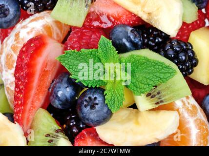 Primo piano della vista dall'alto di un'insalata di frutta con fragole, arance, kiwi, mirtilli e banane Foto Stock