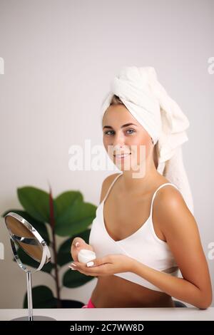 Giovane donna in un accappatoio, porta la bellezza nel bagno Foto Stock