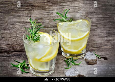Limone fresco con acqua in un bicchiere su tavolo di legno vecchio Foto Stock