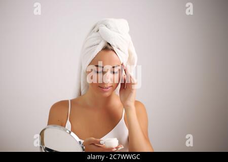 Giovane donna in un accappatoio, porta la bellezza nel bagno Foto Stock