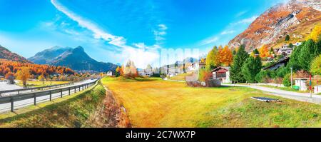 Impressionante scena autunnale nel villaggio di Maloja e strada asfaltata sulla riva del lago Sils (Silsersee). Località: Maloya, Engadina, Cantone Grigioni, Svizzera Foto Stock