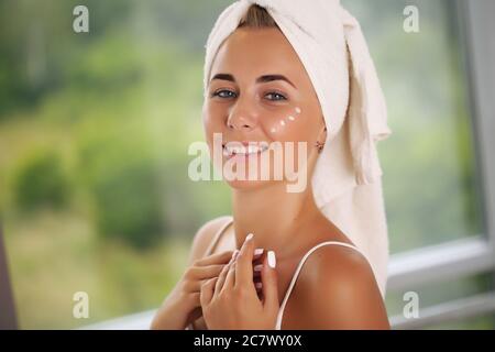 Giovane donna in un accappatoio, porta la bellezza nel bagno Foto Stock