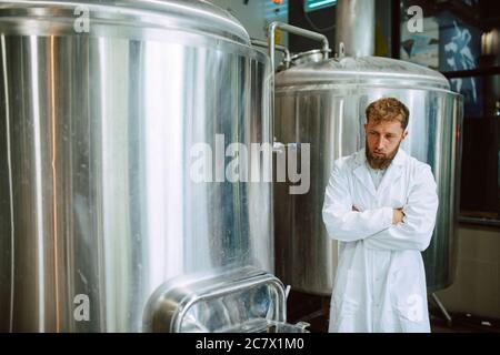 Ritratto di esperto professionale di tecnologo caucasico in uniforme bianca in fabbrica farmaceutica o alimentare - stabilimento di produzione Foto Stock