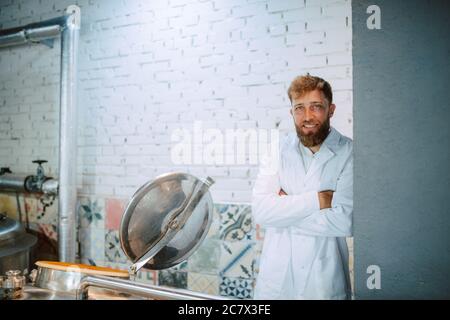 Ritratto di esperto professionale di tecnologo caucasico in uniforme bianca in fabbrica farmaceutica o alimentare - stabilimento di produzione Foto Stock