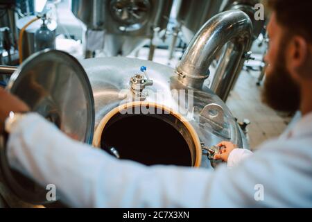 Tecnico caucasico esperto professionale di controllo dei processi industriali in impianti di produzione. Lavoratore industriale con produttività di controllo uniforme Foto Stock