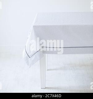 Tavolo di legno bianco con un elegante tovaglia con nero e. texture bianche Foto Stock