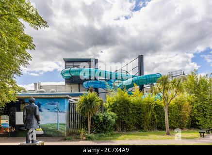 Tubi di effuazione per scivoli d'acqua esterni presso la piscina del parco. Woking Park, Woking, Surrey: servizi della comunità, bagni pubblici moderni Foto Stock