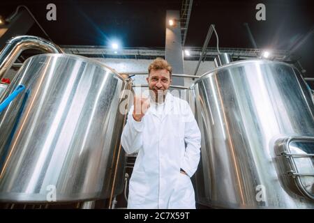 Ritratto di esperto professionale di tecnologo caucasico in uniforme bianca in fabbrica farmaceutica o alimentare - stabilimento di produzione Foto Stock