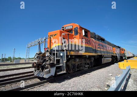 Aurora, Illinois, Stati Uniti. Due locomotive Burlington Northern Santa Fe partono dalla ferrovia Eola Yard con un treno merci locale. Foto Stock