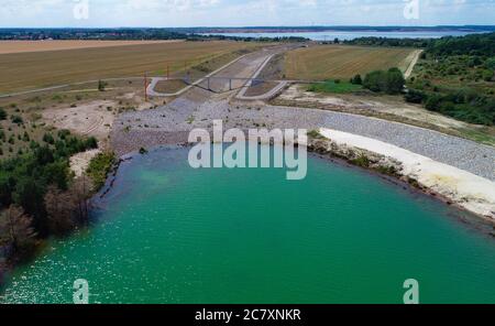14 luglio 2020, Brandenburg, Sedlitz: Il lago di Sedlitz con il ponte per il lago großräschen. Non c'è acqua nel canale artificiale, poiché il livello massimo d'acqua del lago Sedlitz non è ancora stato raggiunto. Il lago Sedlitz fa parte della catena dei laghi Lusaziani Lakeland e si trova nel quartiere Oberspreewald-Lausitz. Da giugno, il foro residuo di estrazione a getto aperto di Sedlitz è stato limato per conto della Lausitzer und Mitteldeutsche Bergbau-Verwaltungsgesellschaft mbH (LMBV). Questa neutralizzazione iniziale viene effettuata con il recipiente di trattamento dell'acqua della LMBV Klara, che era alre Foto Stock