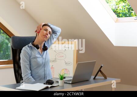 Belle donne che eseguono esercizi e stretching di fronte a un computer portatile. Lavorare a casa, concetto di salute. Foto Stock