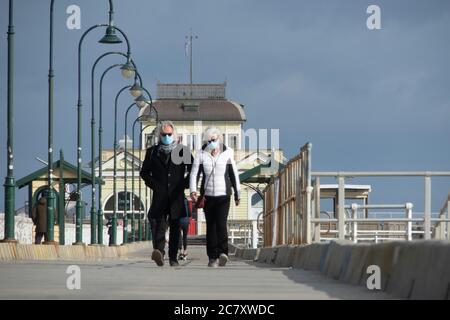 Coronavirus Melbourne Covid-19: Persone che indossano maschere protettive mentre camminano lungo lo storico St Kilda Pier a Melbourne. Foto Stock