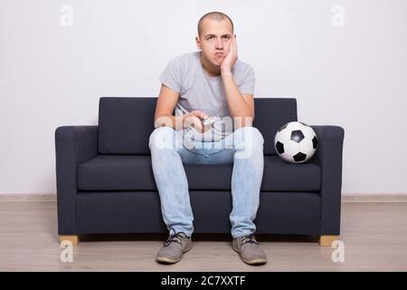 annoiarsi tifosi di calcio che guardano la partita in tv a casa Foto Stock