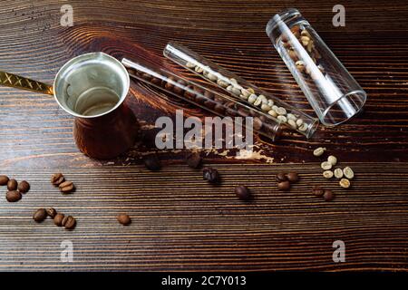 Cezve di caffè e chicchi di caffè su sfondo di legno. Foto Stock
