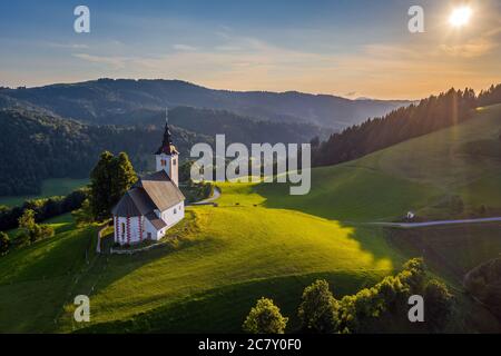 Sveti Andrej, Slovenia - veduta aerea del drone della chiesa di Sant'Andrea (Sv. Andrej) al tramonto nella zona di Skofja Loka. Estate nelle alpi slovene Foto Stock