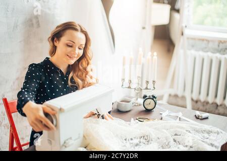 seamstress femmina cucce i vestiti e mettere il filo in ago. Luogo di lavoro di sarto. Persone, lavoro d'ago e concetto di sartoria - uomo su misura infilare ago Foto Stock