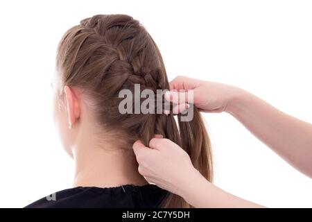 stilista capelli che fa la treccia alla giovane donna isolato su sfondo bianco Foto Stock