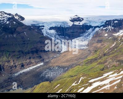 Vista dal picco Kristinartindar con le lingue del ghiacciaio Skaftafellsjokull, cascate, colorate montagne di rhyolit, sperone di Vatnajokull nel Parco di Skaftafell Foto Stock